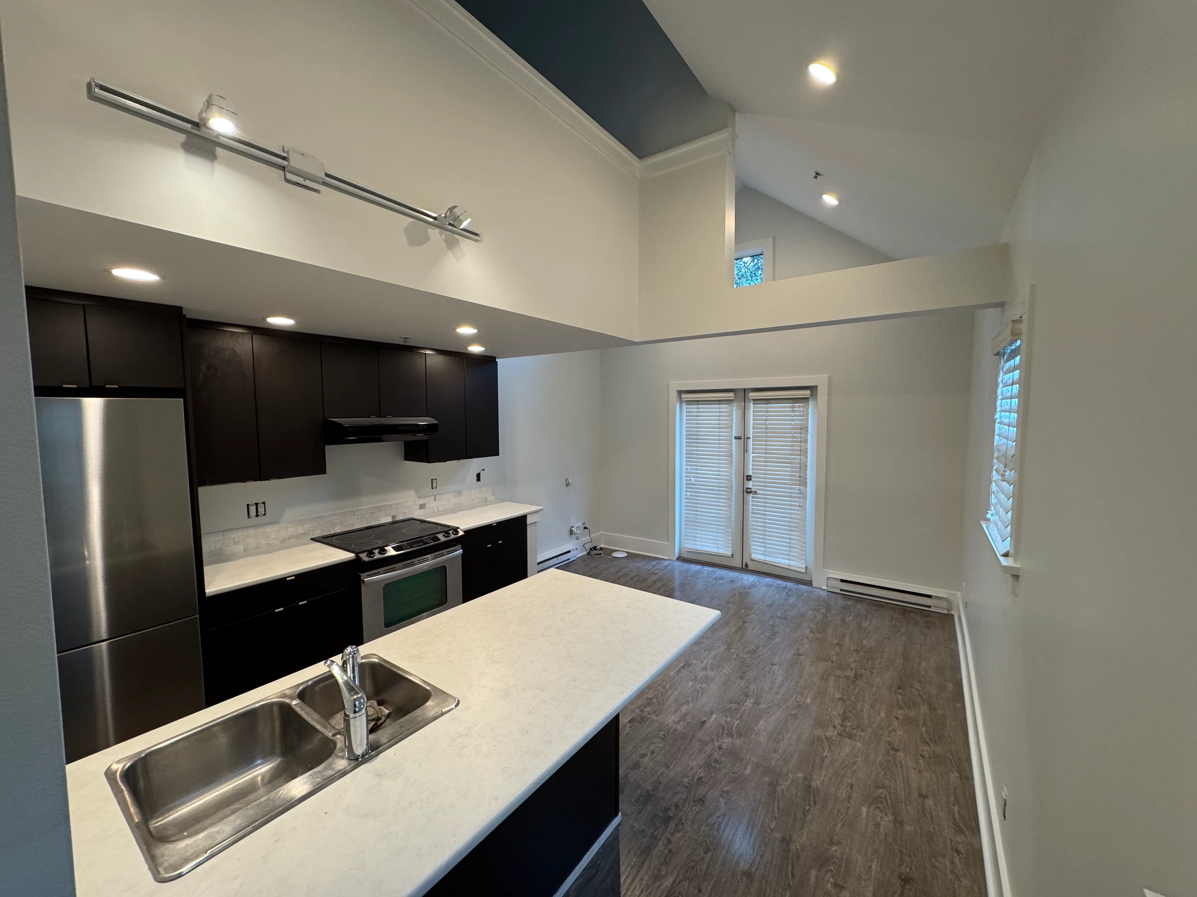 Kitchen island with stainless appliances, looking to the patio doors
